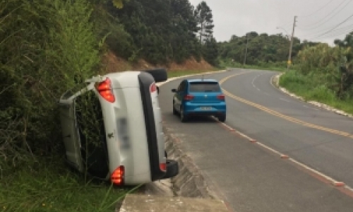 Motorista abandona carro ligado após capotamento em morro