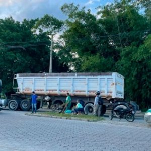 Motociclista tem suspeita de fratura em uma das pernas após colidir contra carreta