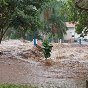 Forte chuva provoca cabeça d'água em cachoeira e correnteza invade ruas