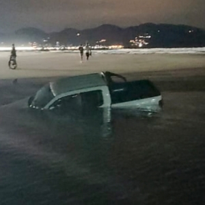 Motorista tenta cruzar rio com caminhonete e veículo fica atolado na água