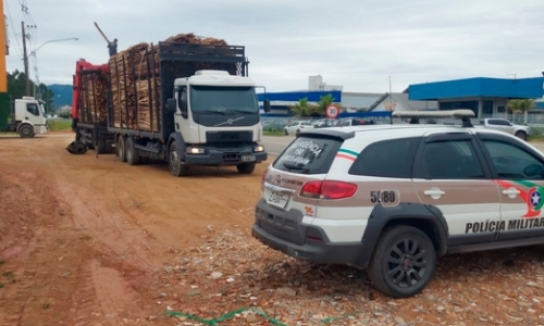 Fiscalização da PM multa motoristas de caminhões carregados de madeira