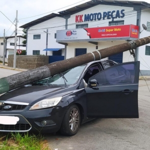 Carro colide em poste após sair da pista; Estrutura cai no veículo 